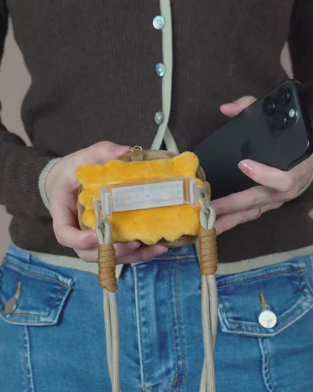 A demonstration of how to use the phone mount on the Bella & Pal 2-in-1 Crossbody to securely hold a phone in place, along with the front pouch functioning as a poop bag holder to store dog waste bags. The video highlights how these features make essentials easily accessible and simplify dog walks.